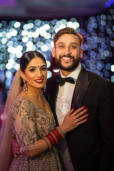 couple-portrait-indoors-with-fairy-lights-behind-them