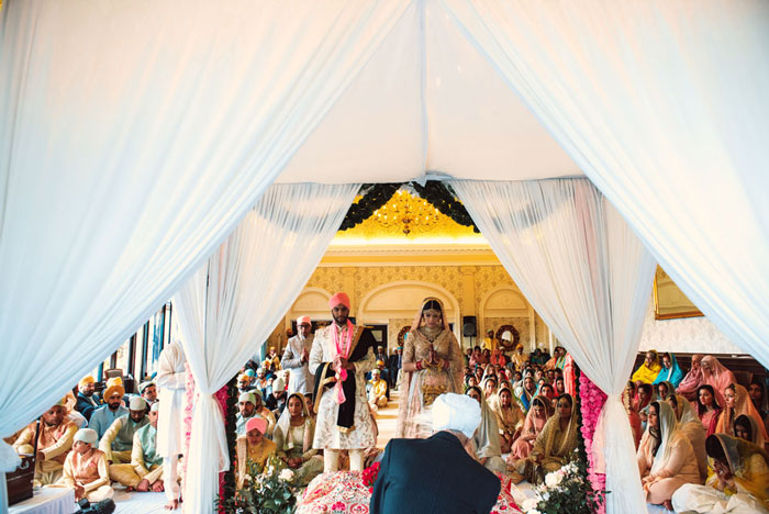 sikh couple praying during anand karaj